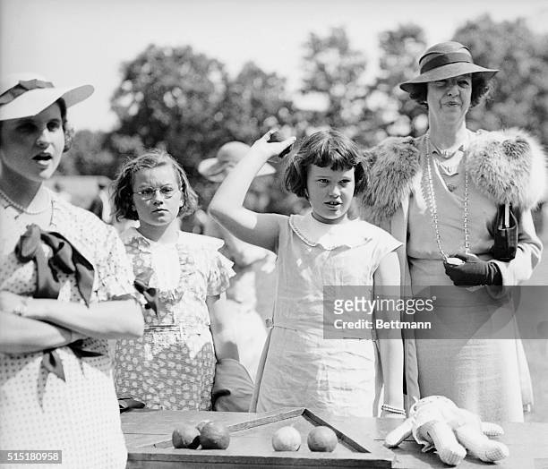 Manhasset, L.I., NY - Mrs. Gertrude Vanderbilt, her aunt and part-time guardian, is pictured watching little Gloria Vanderbilt tossing baseballs for...