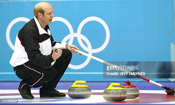 Kevin Martin the skip for the Canada's curling team points his thumb in the direction he hopes the stone will move 15 February, 2002 during his...