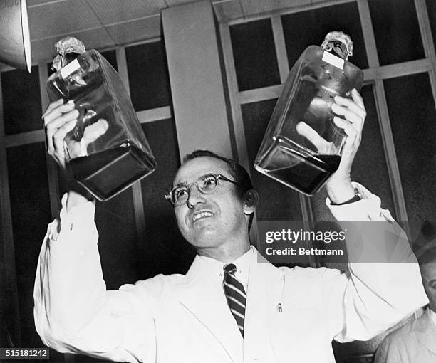 Dr. Jonas Salk displays his polio vaccine which he developed in a University of Pittsburgh laboratory.