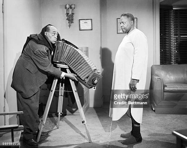 Scene from the "Amos 'N' Andy" CBS TV show that ran from 1951 to 1953. George "Kingfish" Stevens standing behind a camera on a tripod while Andy , at...