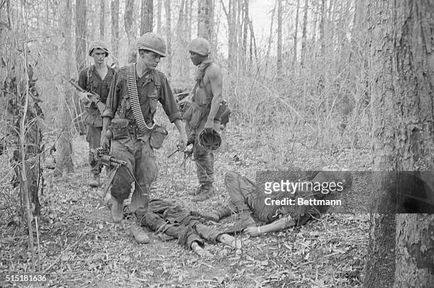 Tay Ninh, South Vietnam- With a sideward glance at a fallen comrade that says more than words can, a soldier pushes on after heavy contact with a...
