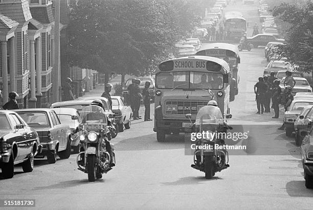 Boston, MA- Helmeted police protect route as school buses carrying black students receive a motorcycle escort upon arrival at South Boston high...