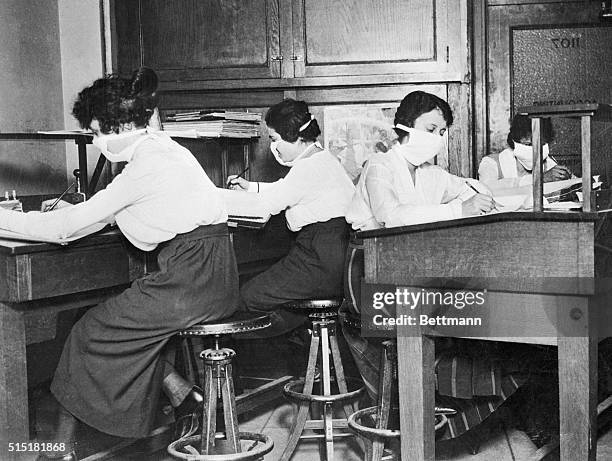 Women wear cloth surgical-style masks to protect against influenza. A worldwide influenza epidemic killed 20 million people between 1918 and 1920.