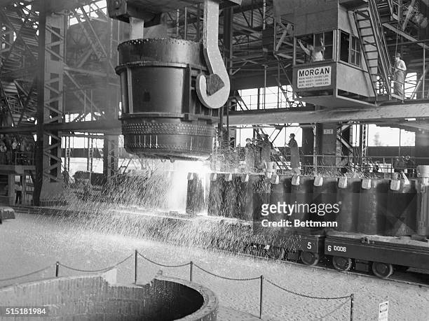 Fontana, CA- Ranging over the molds, 150 tons of molten steel is poured by the ladle crane operator at Henry Kaiser's new Fontana, California steel...