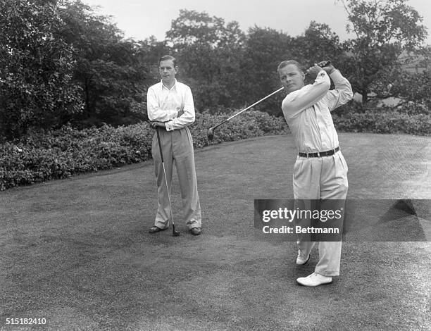 Pine Valley, NJ- Hector Thomson , of the British Walker Cup team, watches Johnny Goodman of the U.S. As the latter drives off at Pine Valley, NJ....