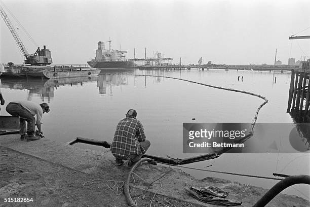 Parcus Hook, PA- A refinery worker mans a pump hose, extracting oil from the surface of the Delaware River, where some 435,000 gallons of crude oil...