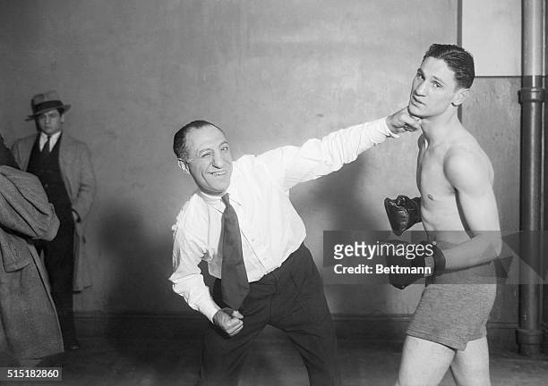 New York, NY: Abe Attell , the greatest featherweight boxer that ever lived, showing his protege, Marty Goldman one of his favorite punches.