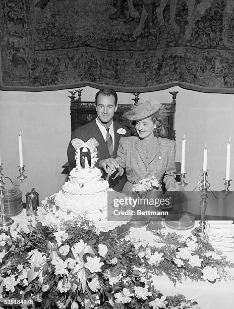 California: Actress Bette Davis and her husband William Grant Sherry smile for the camera as they cut their wedding cake.