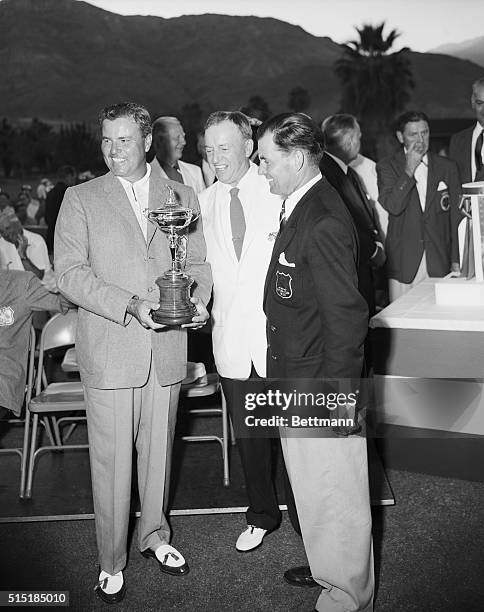 Palm Springs, California- Chick Harbert, , captain of the US team, holds the famed Ryder Cup after the US team of professional golfers won the trophy...