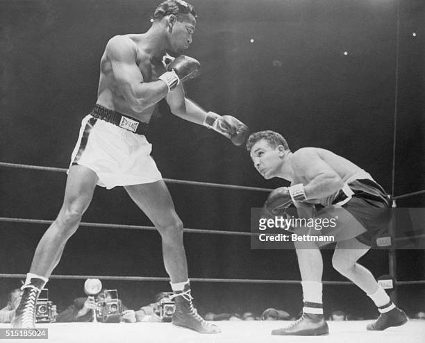 Chicago, IL-: Jake LaMotta is shown here in the "Battle of the Champions" adopting a low crunch to avoid the slashing, longer reach of Robinson. This...