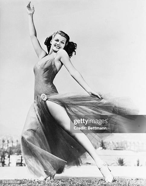 Rita Hayworth shown in a devil-may-care type pose. Undated photograph.