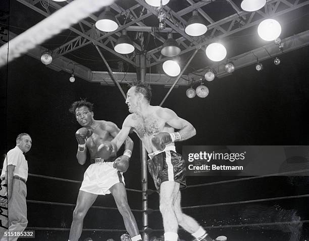 New York, NY- Turn about is fair play, according to Carmen Basilio as he follows through after landing a hard right to the jaw of Sugar Ray Robinson...