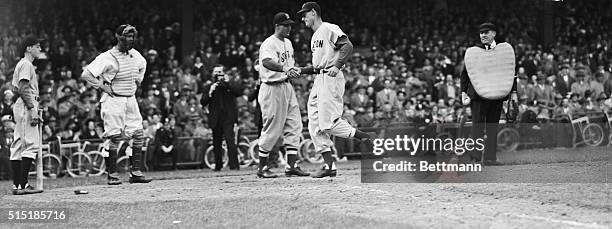 Washington, D.C.- "Lanky" Ted Williams, outfielder for the Boston Red Sox, gets a handshake from Bobby Doerr as he crosses home plate after clouting...