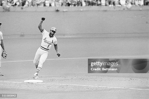 St. Louis, MO- Cardinals' Ozzie Smith holds up his arm as he rounds third base after hitting a solo home run off Dodger Tom Niedenfuer in the bottom...