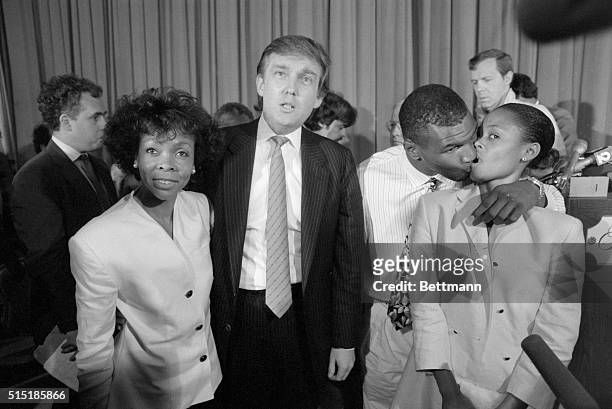 New York, New York- While heavyweight champ Mike Tyson steals a kiss from his wife Robin Givens , real estate developer Donald Trump and Givens'...