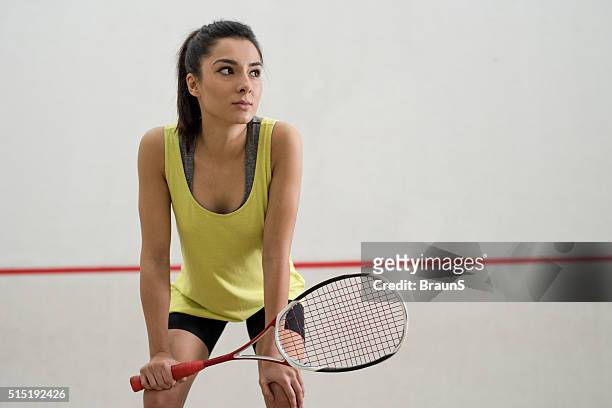 junge nachdenklich sportlerin, die eine pause vom spiel racquetball. - squash racquet stock-fotos und bilder