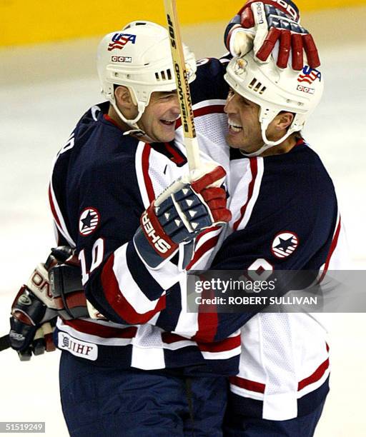 John LeClair of the US celebrates his goal with teammate Mike Modano during their Men's final round Group D Ice Hockey match against Belarus at the...