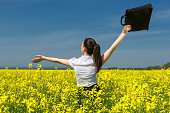 woman with a briefcase on yellow flower field