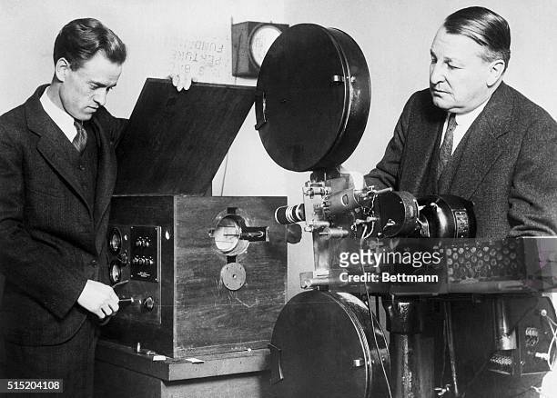 Philo Farnsworth demonstrating transmitter of television set to A.B. Mann, consulting engineer. His invention said to eliminate movable parts and...