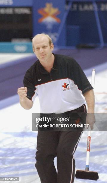 Kevin Martin the skip for the Canada men's curling team pumps his fist after he delivered the last rock to score and beat the Swedish team 20...