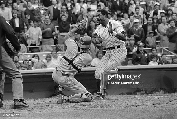 New York, New York- Dave Winfield of the Yankees comes charging into home plate and knocks the ball out of catcher Ed Hearns' glove in third inning...