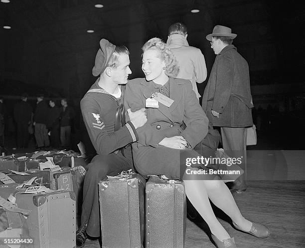 New York, NY- James McGuiness, still in the Navy, welcomes his British war bride at the Seventh Regiment Armory, where brides and babies who arrived...