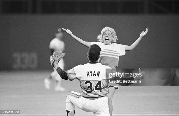 Houston, TX- Houston Astro starting pitcher Nolan Ryan gets ready to receive a big from infamous Morganna, who ran onto the playing field during the...