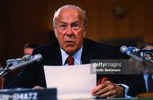 United States Secretary of State George Shultz, seated before the Senate Foreign Relations Committee on the "War Powers Act." He is testifying with...
