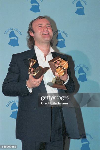 Los Angeles, Calif.: Phil Collins shows off his three Grammy Awards. The veteran performer won awards for album of the year, best pop male vocalist...