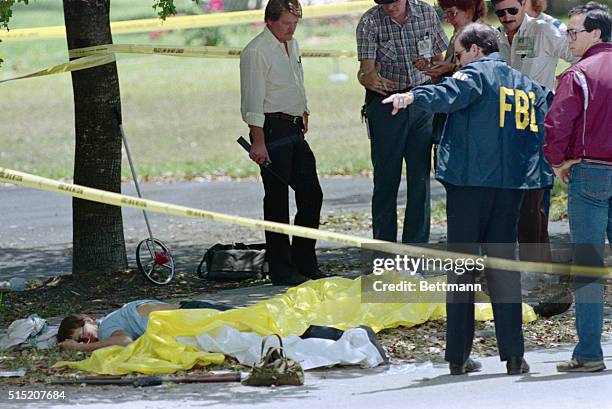 Miami, FL- FBI agents and police examine the scene where two FBI agents and two robbery suspects were killed in a bloody gunbattle 4/11. A shotgun...