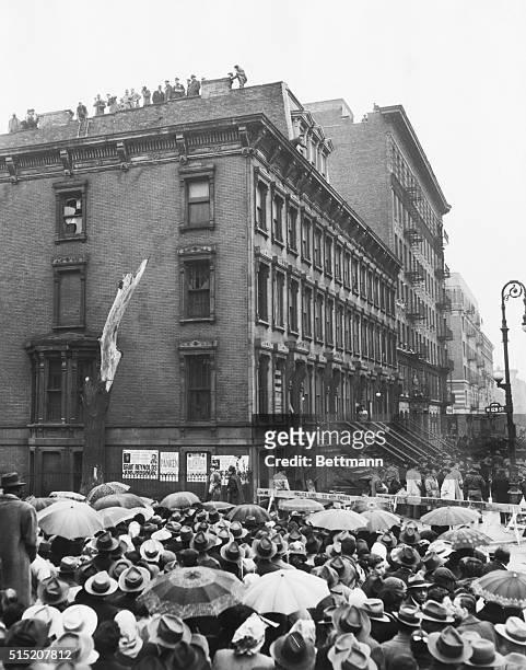 Rain-spattered crowds jam the streets outside the four-story brownstone home of the hermit Collyer brothers as police begin their search of the...