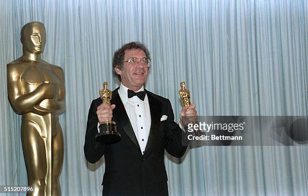 Los Angeles: An elated Sydney Pollack clutches two handfulls of Oscar statuettes after he won an Academy Award for Out of Africa. Pollack also...