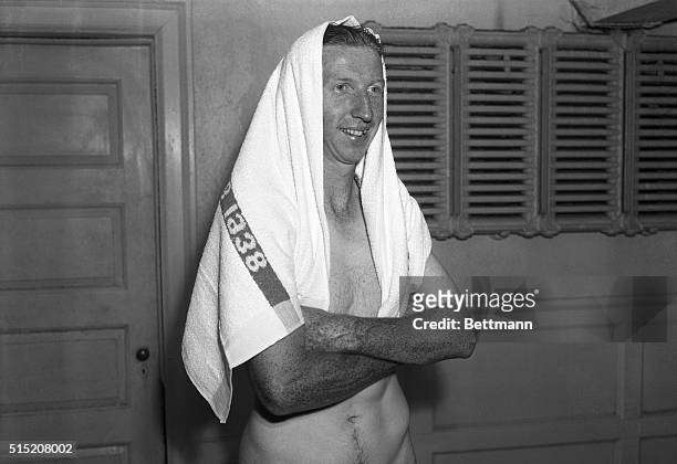 Donald Budge of Oakland, California, world's greatest tennis amateur, his smiling face hooded in a towel after taking a shower, which he well...