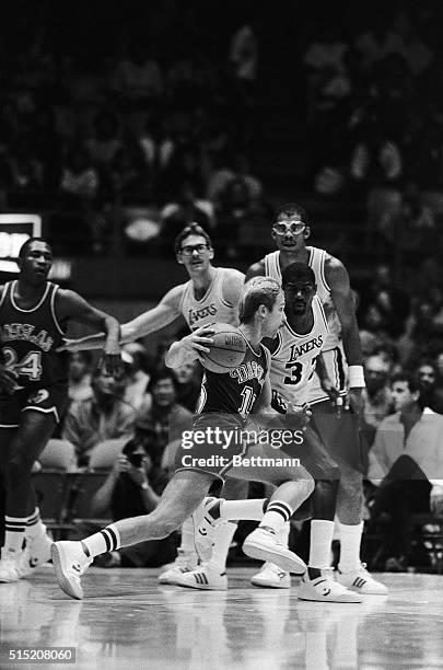 Dallas Mavericks' Brad Davis has his work cut out for him as he attempts to drive past Los Angeles Lakers' Magic Johnson during first quarter action...