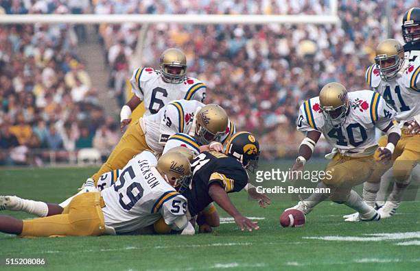 Pasadena, California: Iowa running back Ronnie Harmon fumbles the ball during the 1st quarter. UCLA linebacker Tommy Taylor recovers as UCLA...