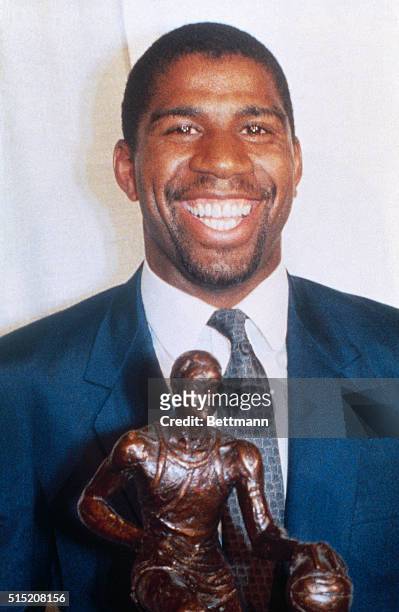 Earvin "Magic" Johnson, a guard for the Los Angeles Lakers holding his 1987 NBA MVP trophy.