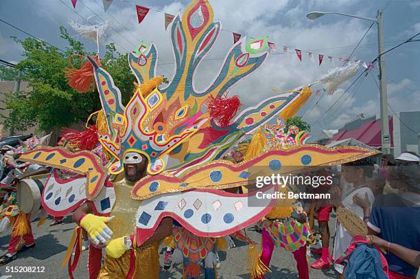 Miami: With a fierce horned-toad mask and danging out a marching beat with cow bells, a Bahamanian Junkanoo dancer celebrates at the Miami/Bahamas...