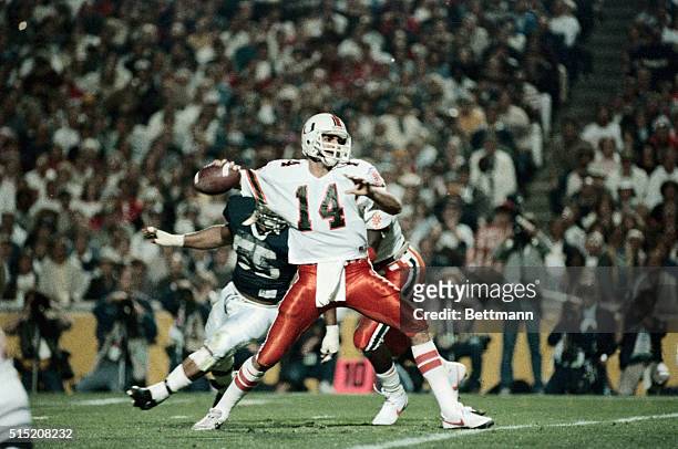 Tempe, Arizona: Under pressure from Penn State tackle Tim Johnson Miami quarterback Vinny Testaverde aims down field during first quarter action at...