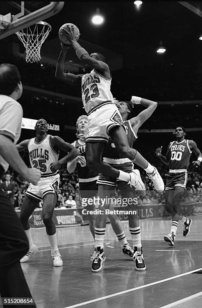Bulls' Michael Jordan flies through the air in front of Celtics' Larry Bird and Dennis Johnson, right behind Jordan, in the first quarter of the...
