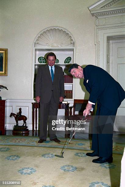 President Reagan tests out his new putter, given to him by recent U.S. Open winner Ray Floyd.