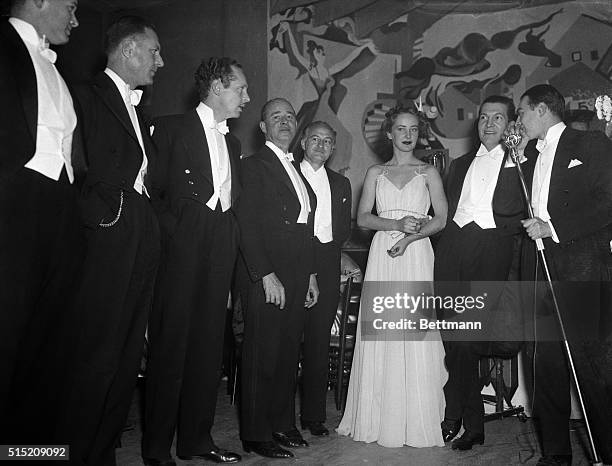 Photographic model Wilma Baard is shown with some of her fifteen uncles who introduced her to Cafe Society in a hilarious gag aimed at the costly...