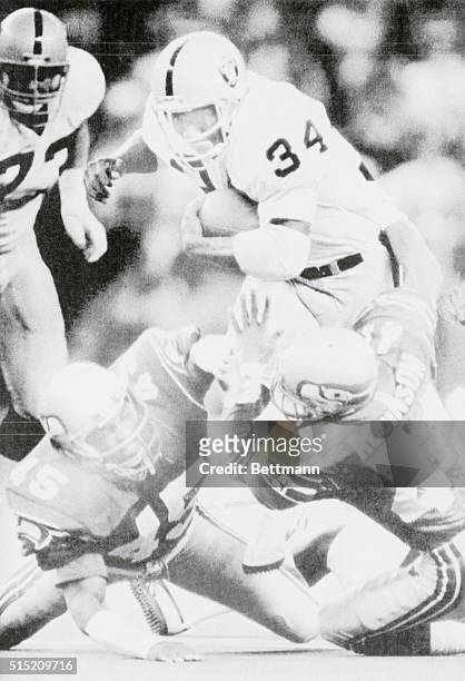 Los Angeles rookie running back Bo Jackson is dragged down by Seattle defensive back Kenny Easley and safety Eugene Robinson for a 15-yard gain...