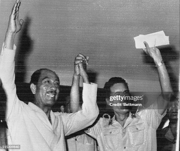 Egyptian President Anwar Sadat and Libyan strongman Colonel Muammar al-Qaddafi wave to the crowd in Benghazi, Libya August 2 after they announced an...