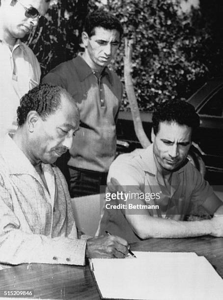 President Anwar Sadat and Libyan leader Colonel Muammar al-Qaddafi look over communiqué upon conclusion of three days of talks here 8/29. Sadat and...