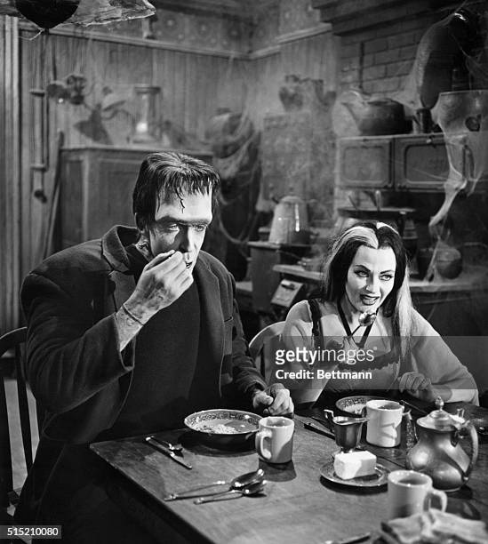 Actors Fred Gwynne and Yvonne DeCarlo share an undoubtedly ghoulish breaksfast in their roles as Herman and Lily Munster on The Munsters television...