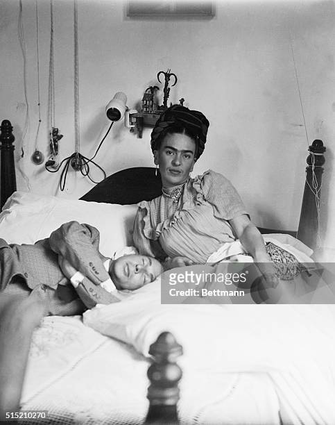 Frida Kahlo: 1910-1954. Mexican painter, with sleeping man. She is the wife of Diego Rivera. Photograph, 1944.