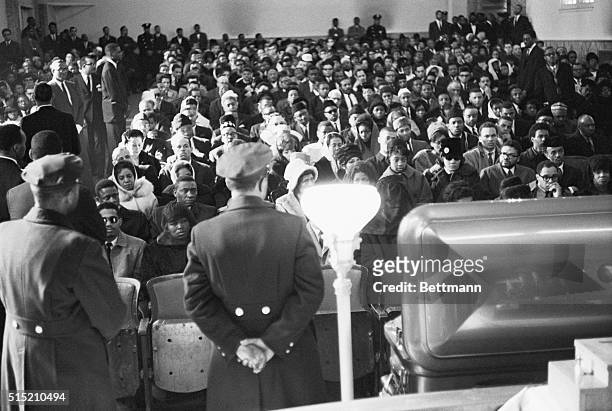 New York, NY: Framed by two policemen, Mrs. Betty Little Shabazz, widow of slain Black Nationalist leader Malcolm X, and a crowd of some 1,000 listen...