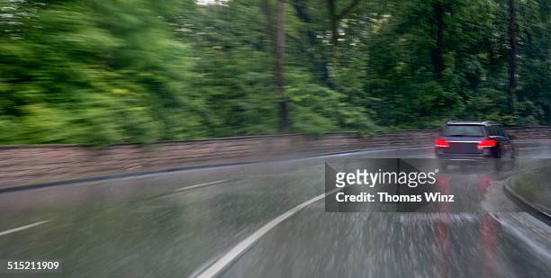 car in heavy rain driving through a curve - regen auto stock-fotos und bilder