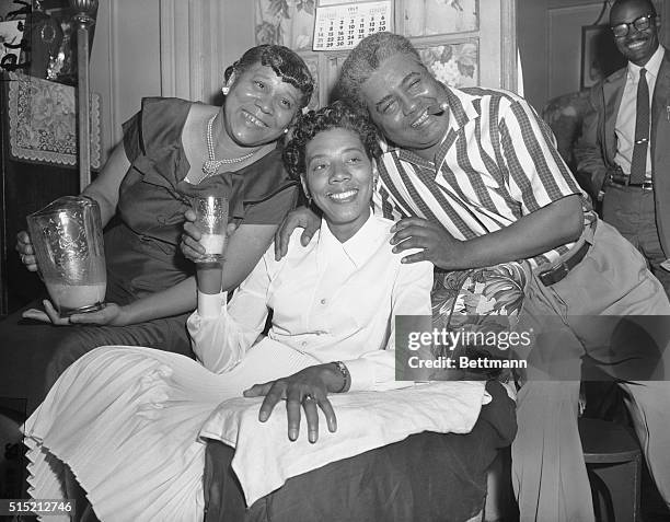 Raising her glass of milk in a toast, Althea Gibson, the new women's Wimbledon singles champion, shows she's glad to be home, as her proud parents,...