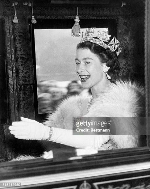 London, England: Queen Elizabeth II, 26 years young, is radiantly happy here as she waves and smiles in acknowledgement of the cheers of the crowd as...